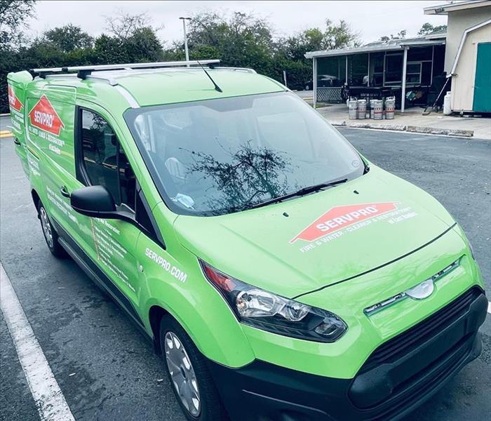 SERVPRO green service van packed in front of a warehouse