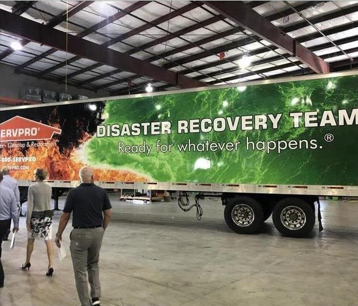 People walking near a trailer " Disaster Recovery Team"